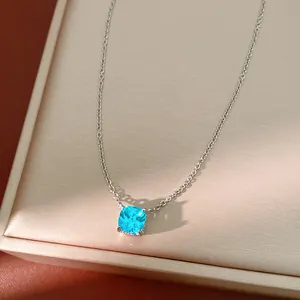 Close-up detail of a cushion-cut blue zircon pendant on a dainty silver chain