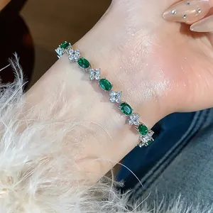 Close-up of elegant silver bracelet with green gemstones and clear flower zirconia detail