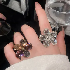 Detailed close-up of sparkling crystal flower open rings worn for an elegant banquet look