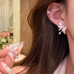 Gros plan de boucles d'oreilles fleuries élégantes avec accents de zircon et nacre