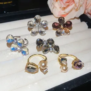 Detailed view of luxury bowknot and flower open rings featuring sparkling crystals