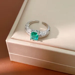 Close-up of elegant emerald green square zircon ring with sparkling diamond band