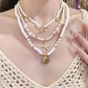 Detail view of layered beaded necklace featuring starfish and shell pendants on model