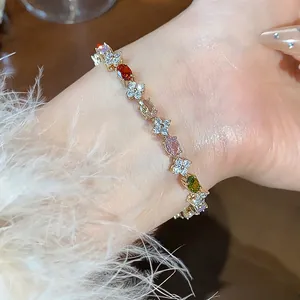 Close-up view of an elegant gold-toned flower bracelet set with multi-colored zircon stones