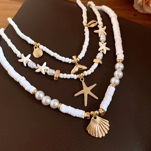 Close-up of white beaded necklaces with gold starfish and shell pendants on brown leather.