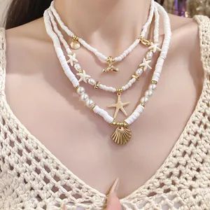 Detailed close-up showing white polymer clay beads with gold shell and starfish charms
