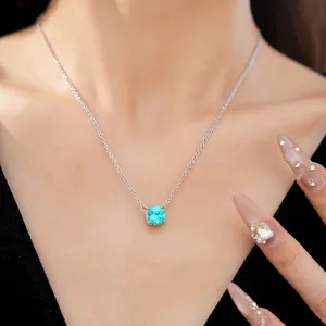 Close-up view of an elegant square-cut blue zircon pendant necklace on a model's neck