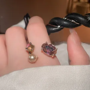 Close-up of luxury open ring with oval purple gemstone and pearl on index finger