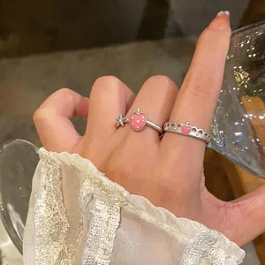 Primo piano di anelli con fragola e cuore a corona su una mano in stile coreano