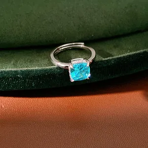 Detailed view of an adjustable silver ring featuring a vibrant square blue zircon stone.