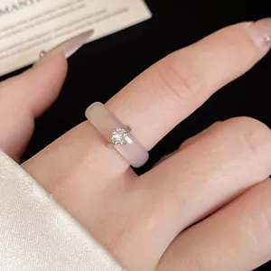Primer plano de un elegante anillo de circón y calcedonia usado en un dedo femenino