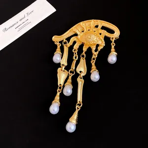 Dettaglio della spilla vintage malocchio in oro con eleganti nappe di perle bianche