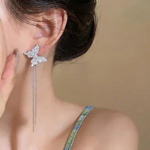 Close-up of sparkling zircon butterfly earrings with long elegant silver tassels