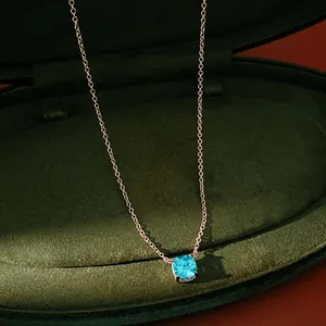 Detailed view of a light blue cushion-cut zircon pendant on a rose gold chain inside a box