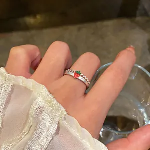 Primo piano di un anello regolabile a fragola in argento con delicati dettagli in pizzo.