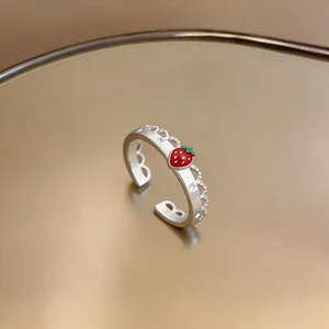 Vista dettagliata di un anello in argento con ciondolo a fragola rossa e zirconi brillanti