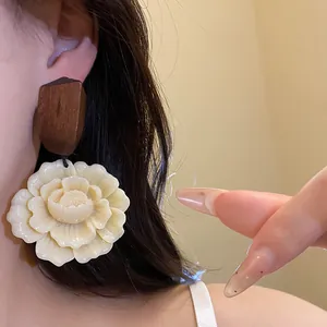 Detailansicht eleganter cremefarbener Resin-Blumenohrringe mit geometrischem Holzaufsatz