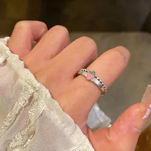 Dettaglio di un anello a fragola in smalto rosa con una delicata fascia in pizzo argento
