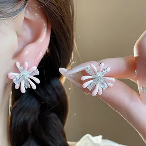 Close-up of pink enamel flower stud earrings with sparkling cubic zirconia center