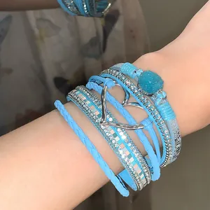 Detailed view of bohemian blue multi-layer leather bracelet with heart and crystal