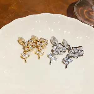 Dettaglio di eleganti orecchini a clip a fiore con zircone in oro e argento