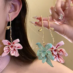 Detailed macro view of elegant handmade enamel flower drop earrings in pink and mint green