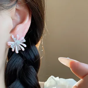Detailed macro shot of pink enamel firework flower stud earrings with zircon stones