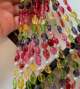 Close-up of vibrant candy-colored beaded jewelry strands with pearls and gold spacers