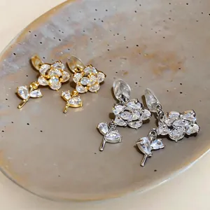 Vista dettagliata di eleganti orecchini a clip a fiore placcati oro e argento con zirconi