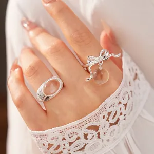 Elegant silver bow ring with zircon accents and a dangling clear resin bead jewelry