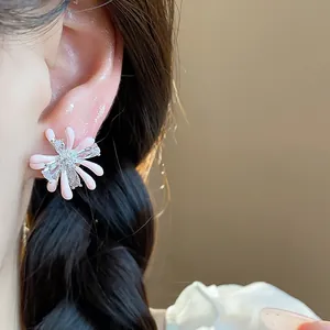 Detailed view of pink enamel flower stud earrings with sparkling zircon accents