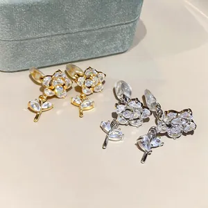 Dettaglio orecchini a clip a forma di fiore placcati oro 14k con petali in zircone