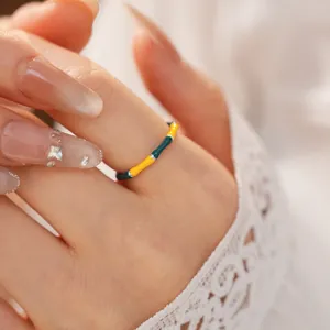 Close-up macro view of a vintage colorful enamel bamboo joint open ring on a woman finger