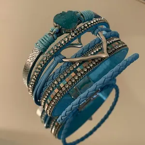 Close-up detail of Bohemian blue multi-layer leather bracelet with heart charm and crystals