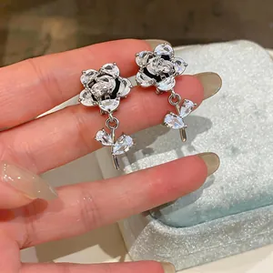 Dettaglio di orecchini a clip a fiore in zircone con eleganti foglie di cristallo pendenti