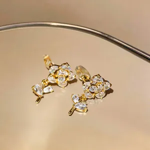 Primo piano dettagliato di orecchini a clip a fiore placcati in oro 14k con zirconi