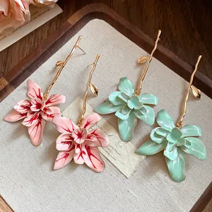 Detailed view of elegant floral drop earrings with a dripping oil finish on a tray