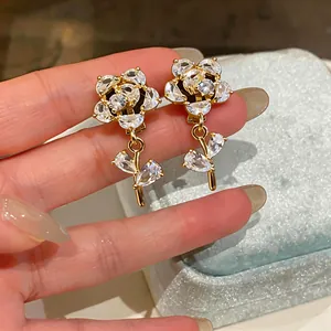 Dettaglio ravvicinato di orecchini a clip a fiore in zircone placcati oro 14k.