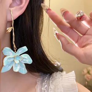 Detailed view of elegant light blue enamel flower drop earring worn by a model.