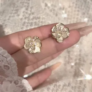 Close-up detail of French vintage camellia stud earrings with sparkling crystals