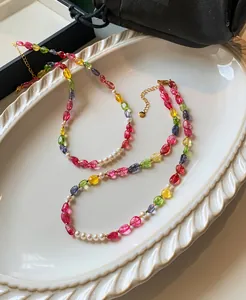 Detailed view of candy-colored crystal beads and pearls on an elegant ceramic tray.