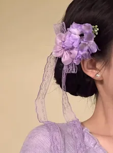 Vista dettagliata di un fermaglio per capelli a fiore viola con eleganti nastri di pizzo