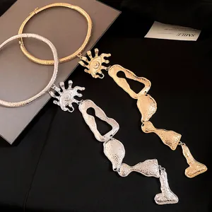Détail de colliers ras-du-cou géométriques à glands dorés et argentés avec motif œil de soleil