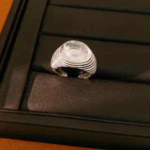 Close-up of a silver-toned open ring featuring a large clear resin cabochon stone