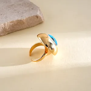 Detailed close-up of a gold adjustable ring featuring a vibrant blue resin evil eye