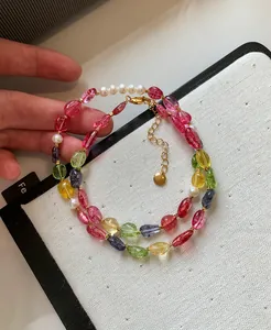 Detailed view of dopamine style candy-colored crystal beads and pearl necklace with gold clasp