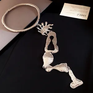 Gros plan de collier ras du cou argenté géométrique irrégulier avec pendentif serrure