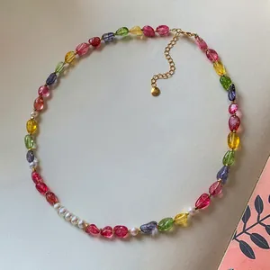 Detail view of vibrant candy-colored crystal beads and white pearls on a gold-toned necklace