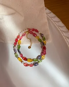 Detailed macro shot of candy-colored crystal beads and pearl necklace with gold tag