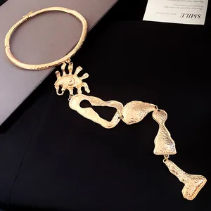 Vue détaillée d'un collier ras du cou doré avec des glands géométriques irréguliers